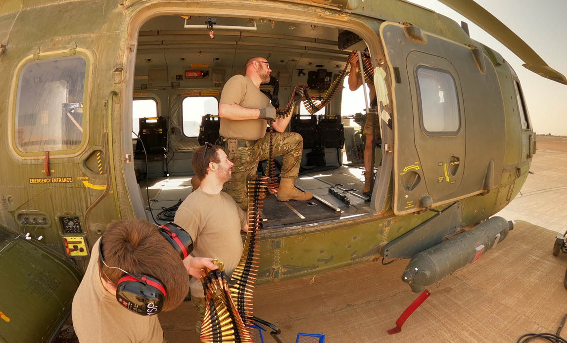 EH101 helikopteren tunge maskingevær forsynes med ammunition.