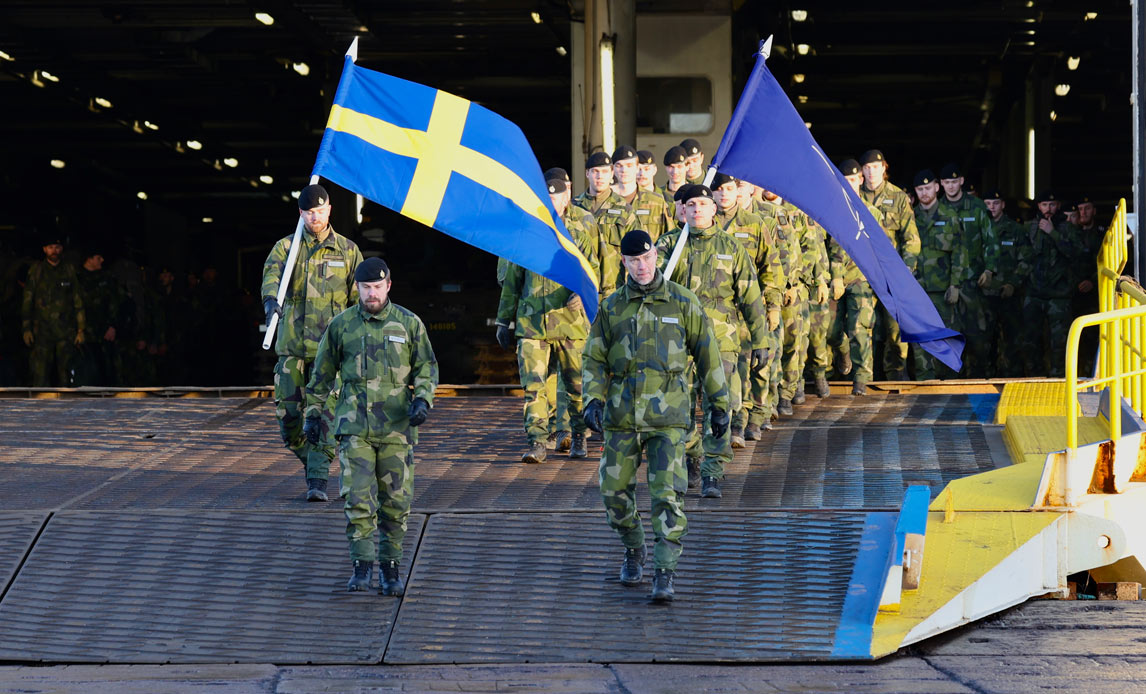 De svenske soldater går fra borde i Letland