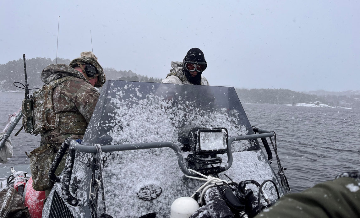 Dykkere fra Søværnets Dykkertjeneste under øvelse Arctic Specialist i en RHIB med sne og is