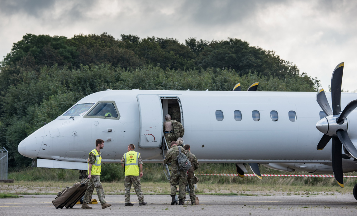 Dansk personel stiger ombord på civilt fly på vej mod Baltikum.