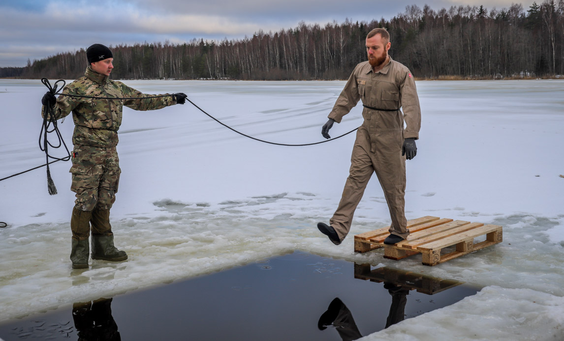 Soldat hopper i iskold sø.