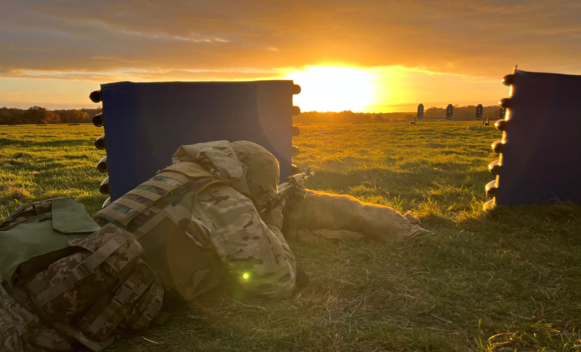 Soldat skyder mens solen går ned